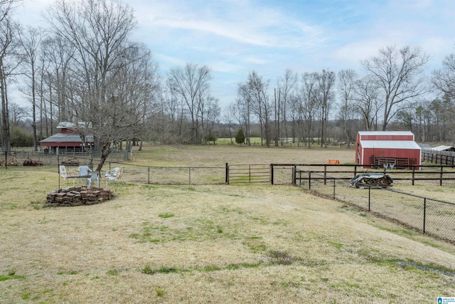 view of yard featuring a rural view, an outdoor structure, and fence