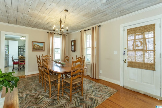 dining room with an inviting chandelier, ornamental molding, wood ceiling, wood finished floors, and baseboards