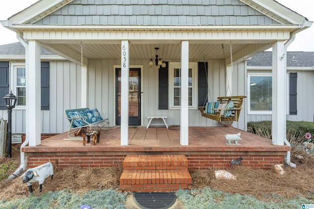 view of exterior entry featuring a porch and board and batten siding