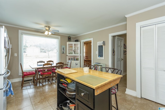 dining room with ornamental molding, baseboards, and a ceiling fan