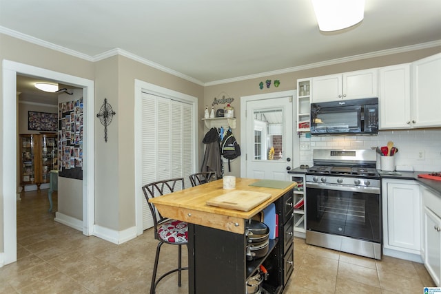 kitchen with black microwave, white cabinets, backsplash, gas stove, and crown molding