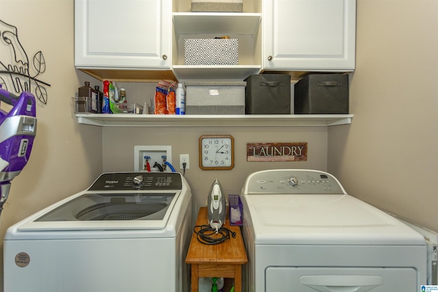 laundry area with independent washer and dryer and cabinet space