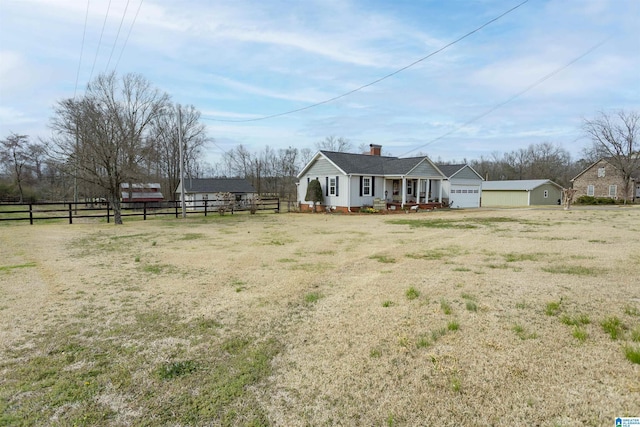 view of front facade with a chimney and fence