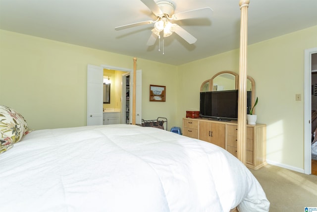 bedroom with light carpet, ceiling fan, ensuite bathroom, and baseboards