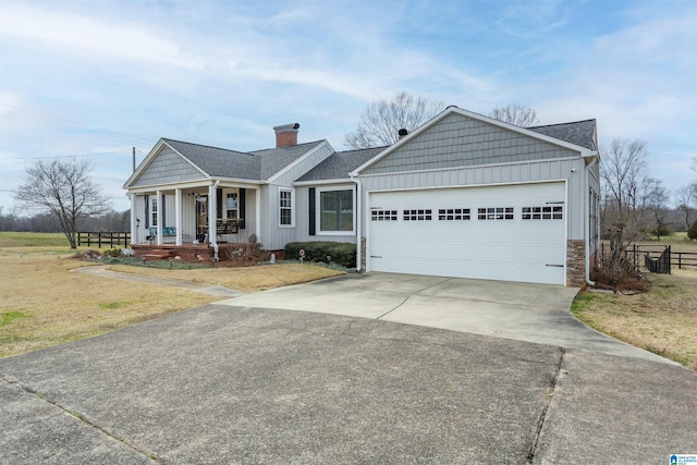 view of front facade featuring driveway, an attached garage, a porch, and board and batten siding