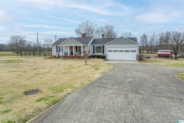 ranch-style house featuring driveway, an attached garage, fence, a front lawn, and a porch