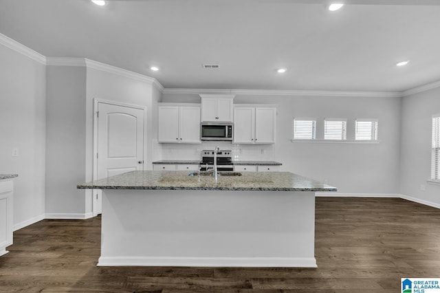 kitchen featuring light stone counters, dark wood finished floors, visible vents, appliances with stainless steel finishes, and a sink