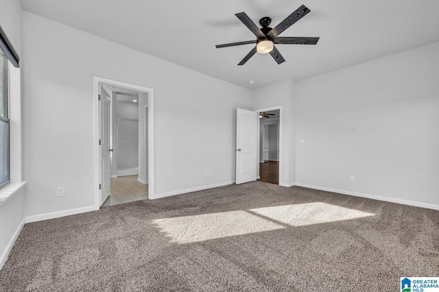 unfurnished bedroom with baseboards, carpet flooring, and ensuite bathroom