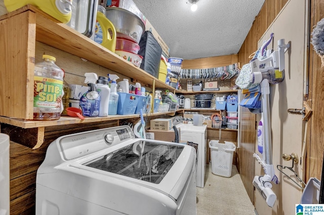 laundry room with a textured ceiling, laundry area, washer and clothes dryer, and tile patterned floors