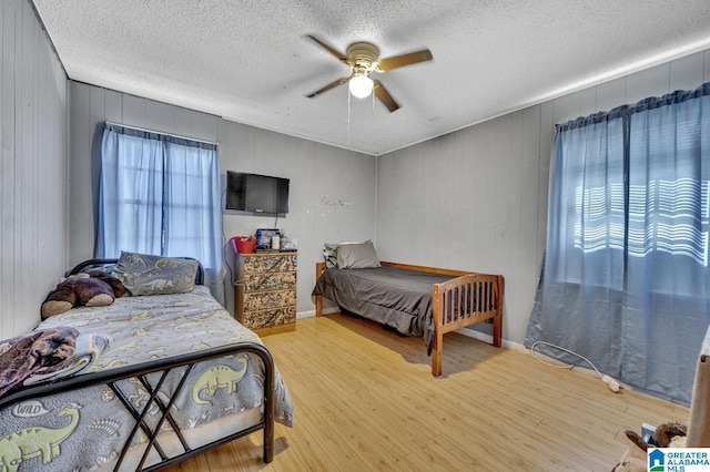 bedroom featuring a textured ceiling, a ceiling fan, and wood finished floors