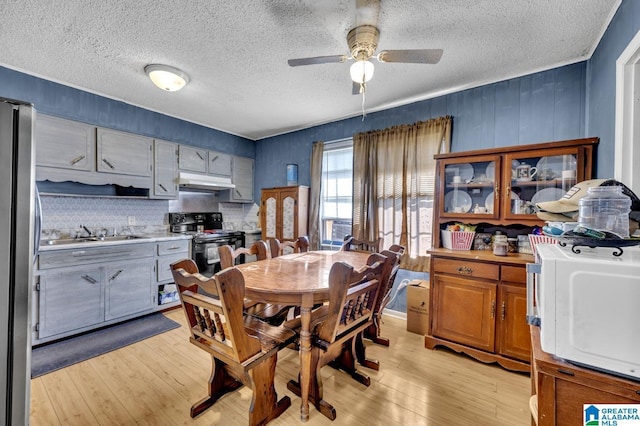 dining room with light wood-style floors, a textured ceiling, and a ceiling fan