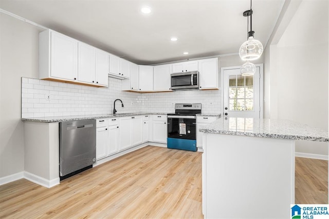 kitchen with light stone countertops, light wood-style floors, appliances with stainless steel finishes, and decorative backsplash