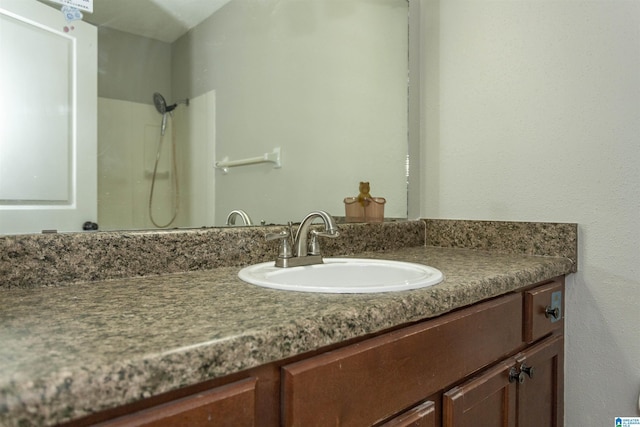 bathroom featuring a shower and vanity