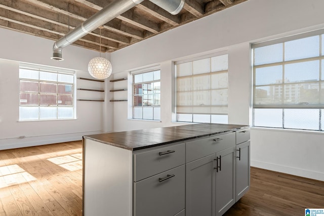 kitchen with a wealth of natural light, dark countertops, baseboards, and dark wood-style floors