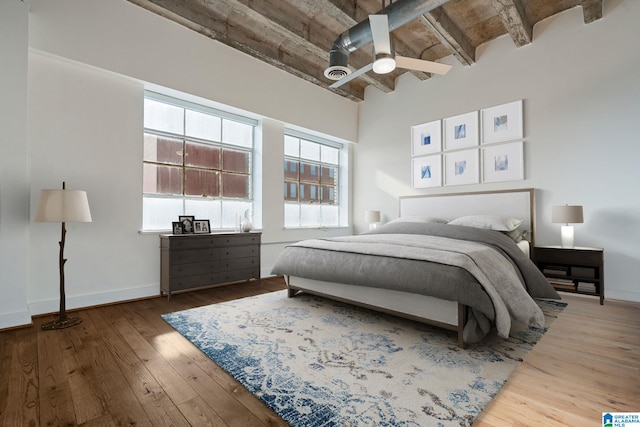 bedroom featuring a ceiling fan, baseboards, and hardwood / wood-style flooring