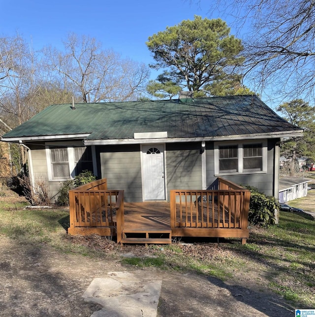 rear view of house featuring metal roof and a deck