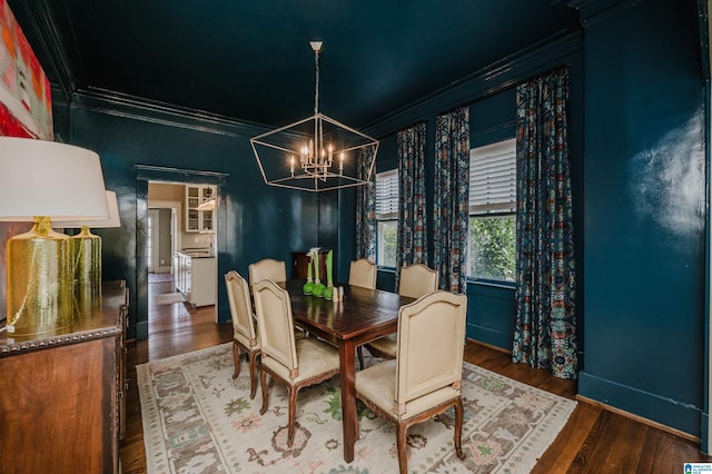 dining area featuring baseboards, wood finished floors, an inviting chandelier, and ornamental molding