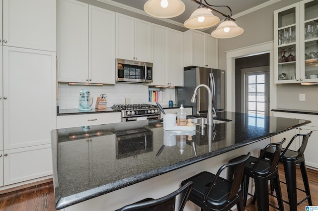 kitchen featuring dark wood-style floors, stainless steel appliances, glass insert cabinets, and tasteful backsplash