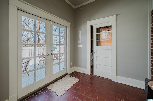 doorway featuring french doors, brick floor, baseboards, and ornamental molding