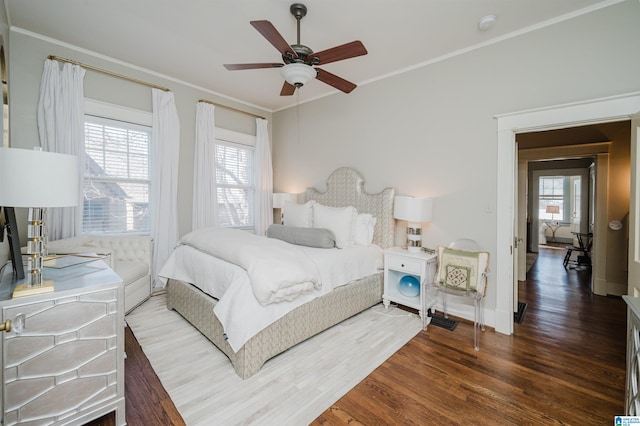 bedroom featuring multiple windows, wood finished floors, and ornamental molding