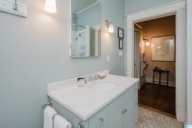 full bath with tile patterned floors, baseboards, walk in shower, and vanity