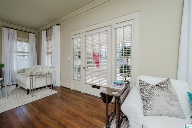 living area featuring wood finished floors and ornamental molding