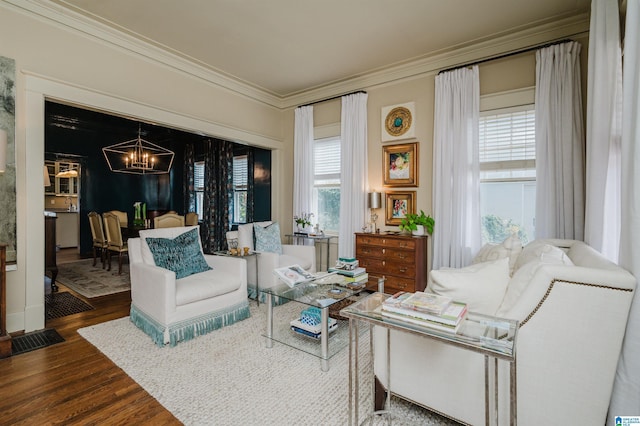 sitting room featuring crown molding, a notable chandelier, and wood finished floors