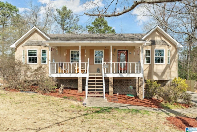 view of front of house with covered porch, a front lawn, and stairs