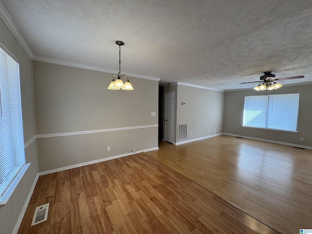 unfurnished room with a textured ceiling, visible vents, and wood finished floors