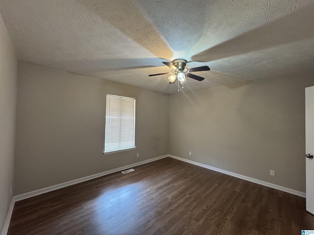 empty room featuring dark wood-style floors, visible vents, ceiling fan, and baseboards