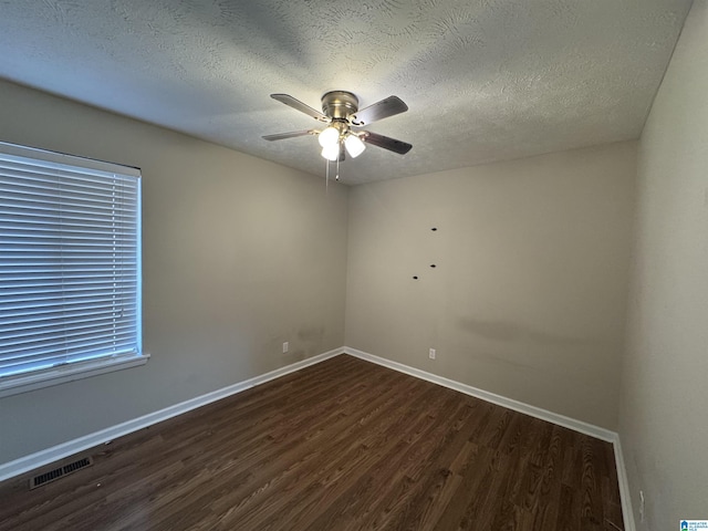 spare room featuring ceiling fan, a textured ceiling, wood finished floors, visible vents, and baseboards