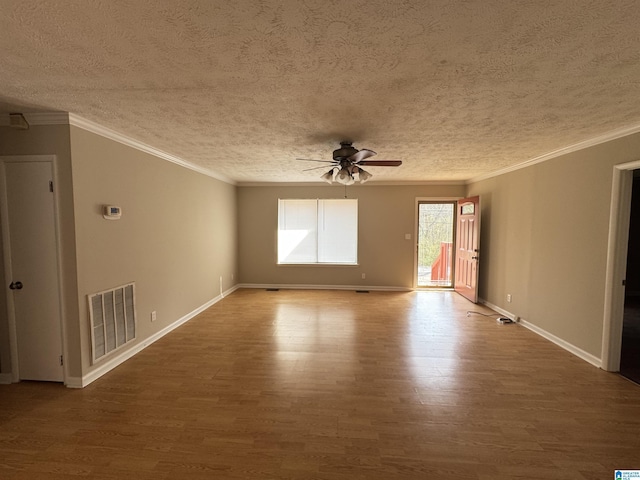 unfurnished room featuring visible vents, ornamental molding, ceiling fan, wood finished floors, and baseboards