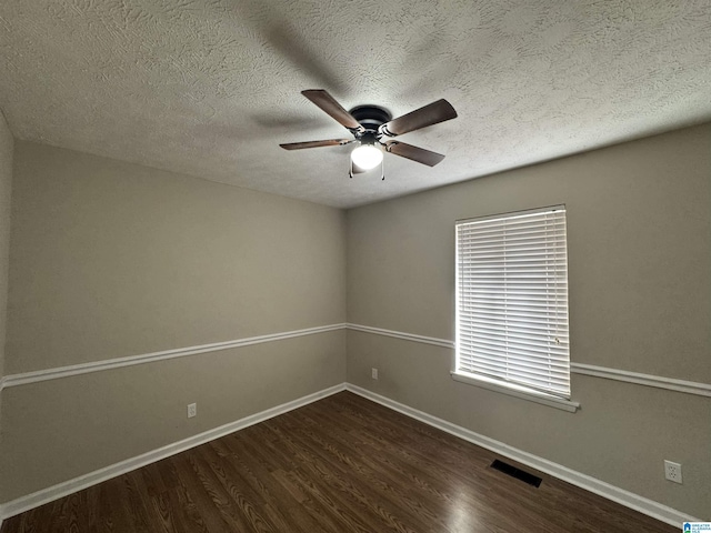 unfurnished room featuring baseboards, visible vents, dark wood-style floors, ceiling fan, and a textured ceiling