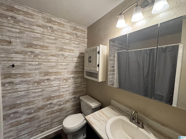 bathroom featuring a textured ceiling, a textured wall, toilet, vanity, and a shower with curtain