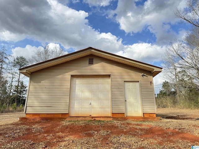 detached garage featuring dirt driveway