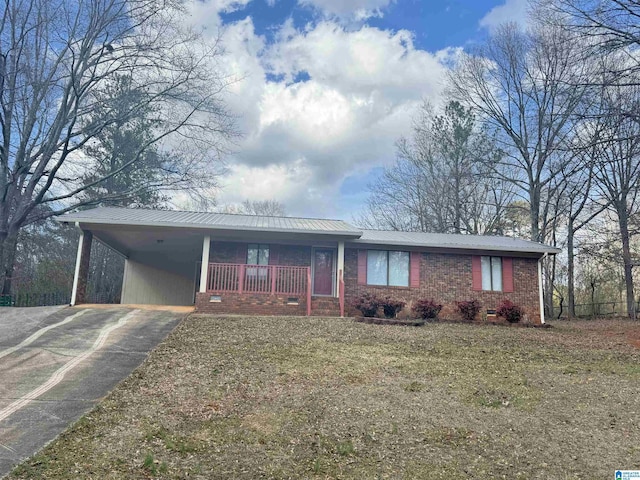 ranch-style home with driveway, metal roof, an attached carport, and brick siding