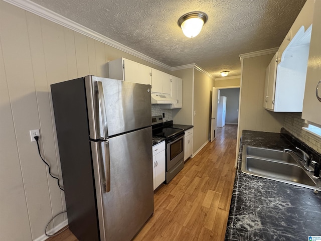 kitchen with stainless steel appliances, dark countertops, a sink, and under cabinet range hood