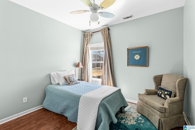 bedroom with ceiling fan, wood finished floors, visible vents, and baseboards