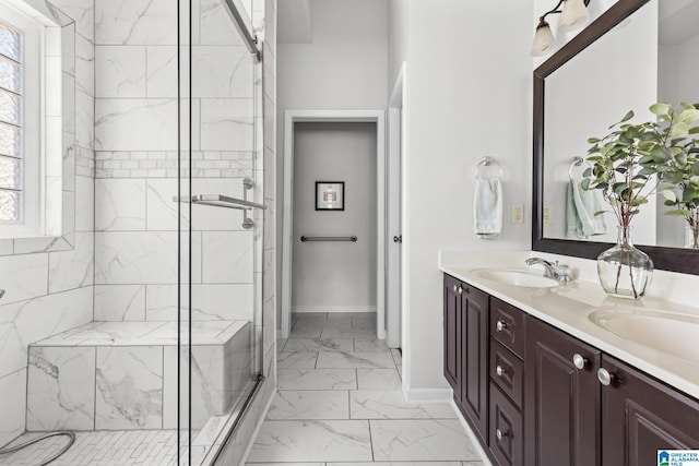 bathroom with marble finish floor, double vanity, a stall shower, a sink, and baseboards