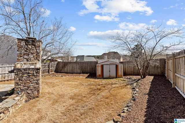 view of yard featuring an outbuilding, a storage unit, and a fenced backyard