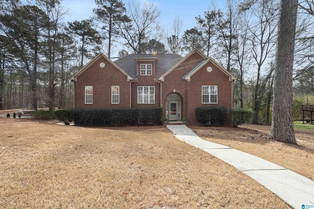 traditional home featuring brick siding and a front yard