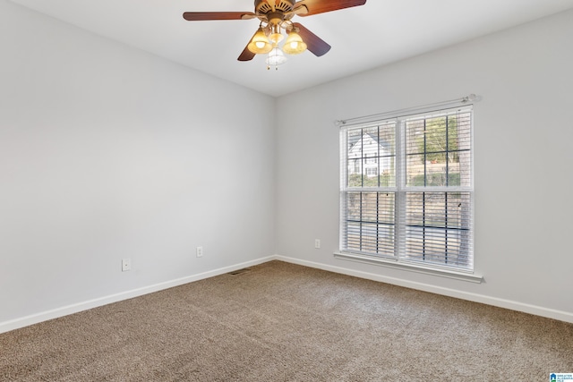 carpeted empty room featuring visible vents, ceiling fan, and baseboards