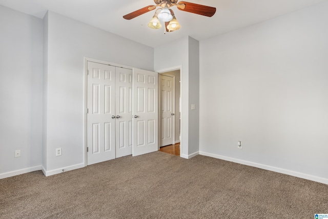 unfurnished bedroom with a closet, carpet flooring, ceiling fan, and baseboards