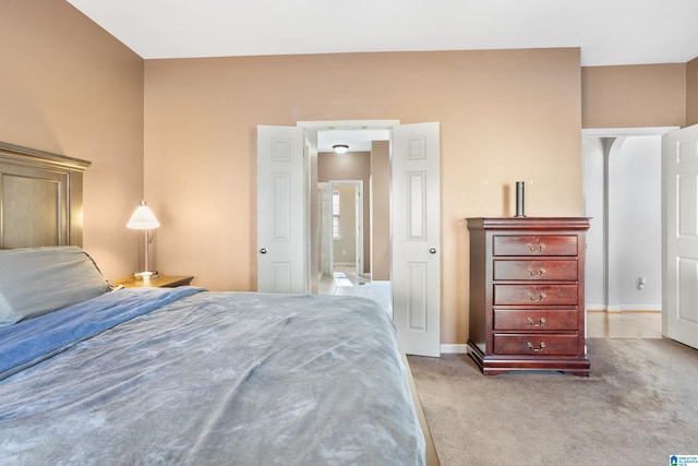 bedroom featuring light carpet and baseboards