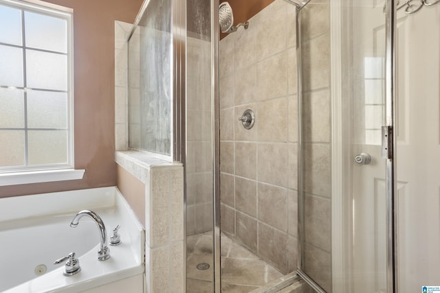 bathroom with a jetted tub, a stall shower, and a wealth of natural light