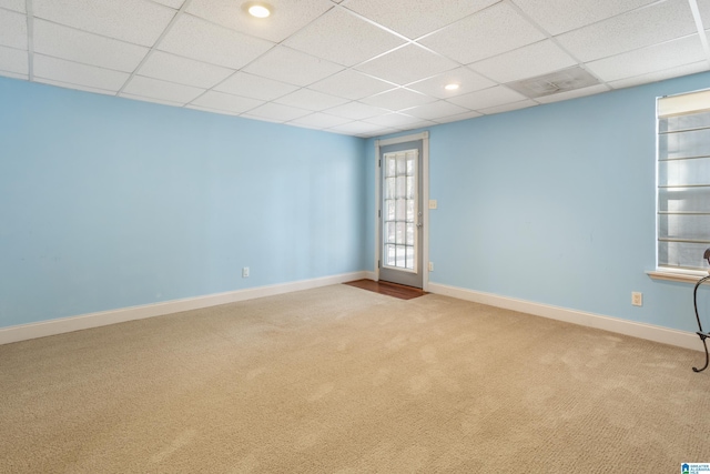 unfurnished room featuring baseboards, a drop ceiling, and carpet flooring