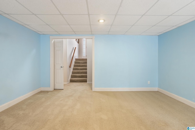 finished below grade area with baseboards, stairway, and light colored carpet