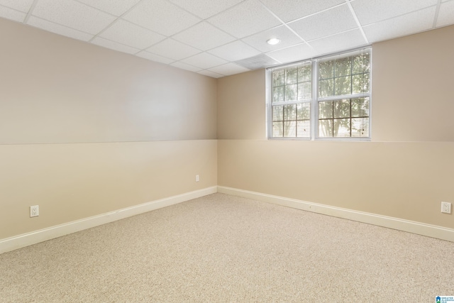 unfurnished room with carpet, baseboards, and a drop ceiling