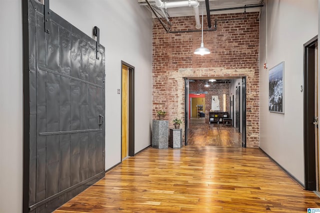 hall featuring wood-type flooring and a high ceiling