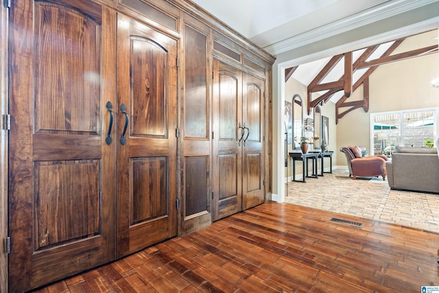 hall featuring dark wood-type flooring, beamed ceiling, visible vents, and baseboards